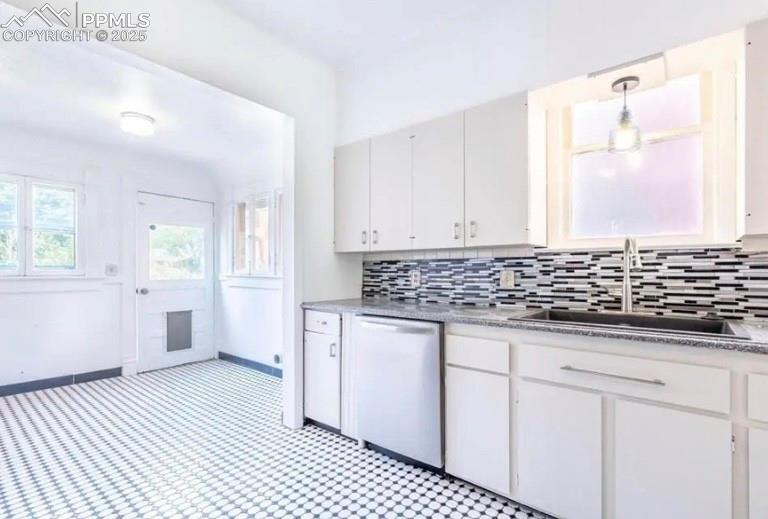 Image 4 of 9: Kitchen featuring tasteful backsplash, dishwasher, white cabinets, and pend