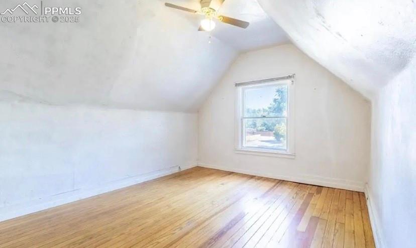 Image 6 of 9: Additional living space with light wood finished floors, lofted ceiling, an