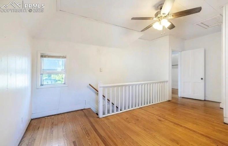 Image 7 of 9: Empty room featuring hardwood / wood-style flooring, attic access, and ceil
