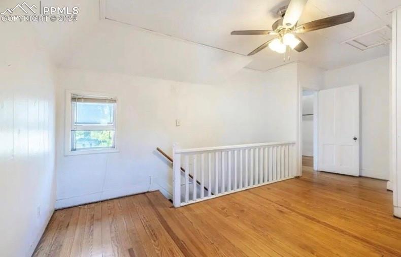 Image 7 of 9: Empty room featuring hardwood / wood-style flooring, attic access, and ceil