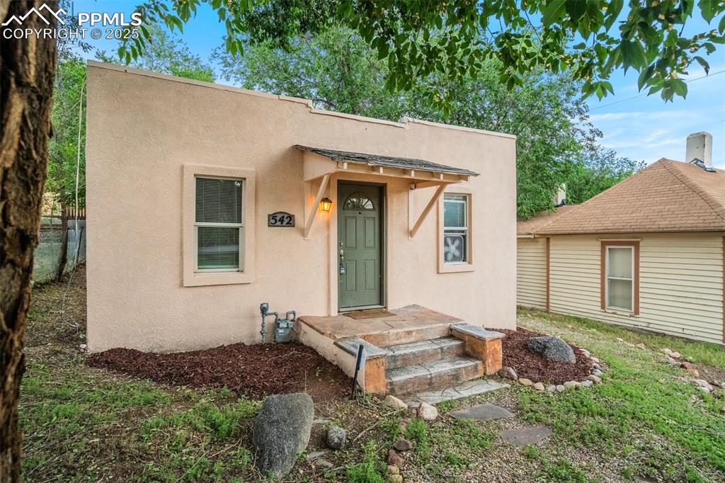 Caption: View of front of home with stucco siding