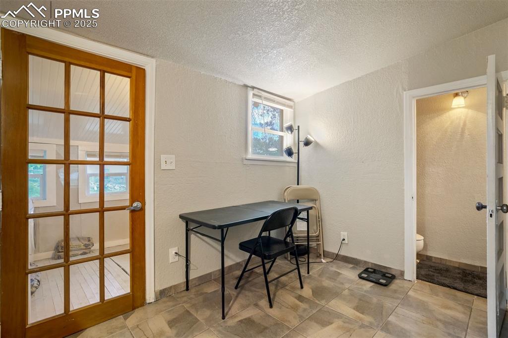 Image 10 of 24: Home office featuring a textured wall and a textured ceiling