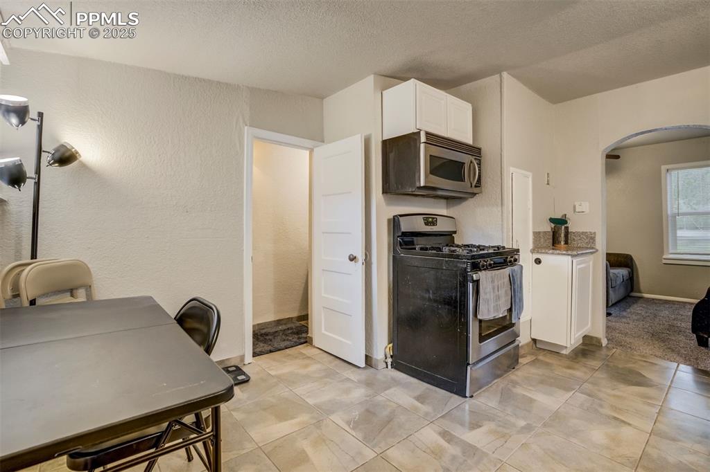 Image 12 of 24: Kitchen featuring appliances with stainless steel finishes, arched walkways