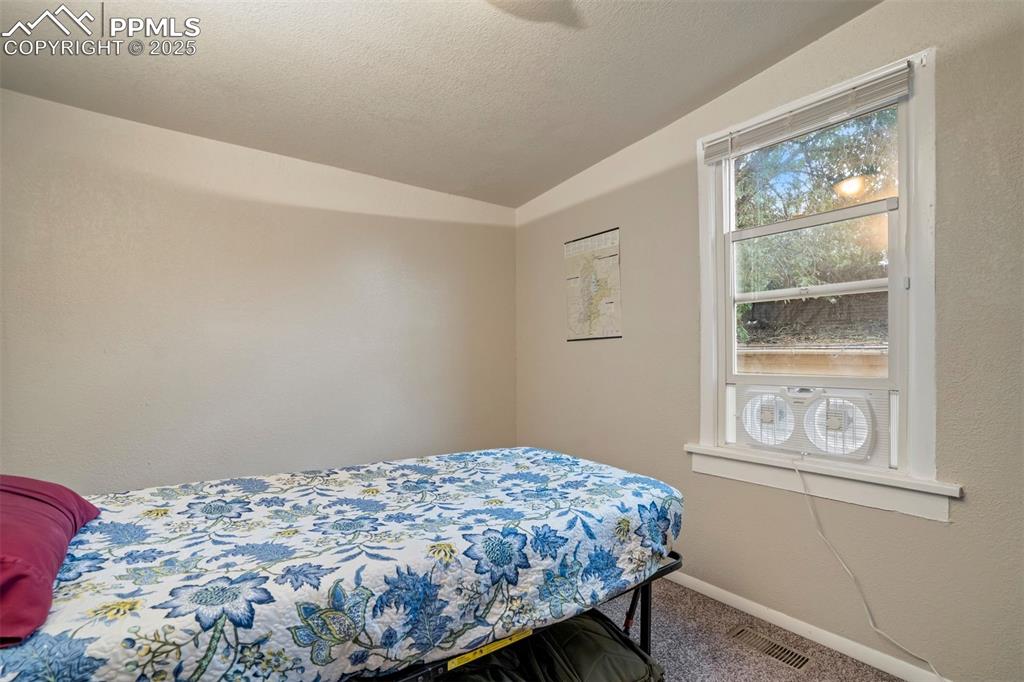 Image 15 of 24: Bedroom with lofted ceiling and carpet