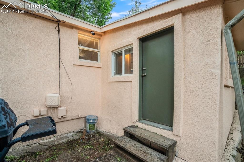 Image 22 of 24: View of exterior entry with stucco siding