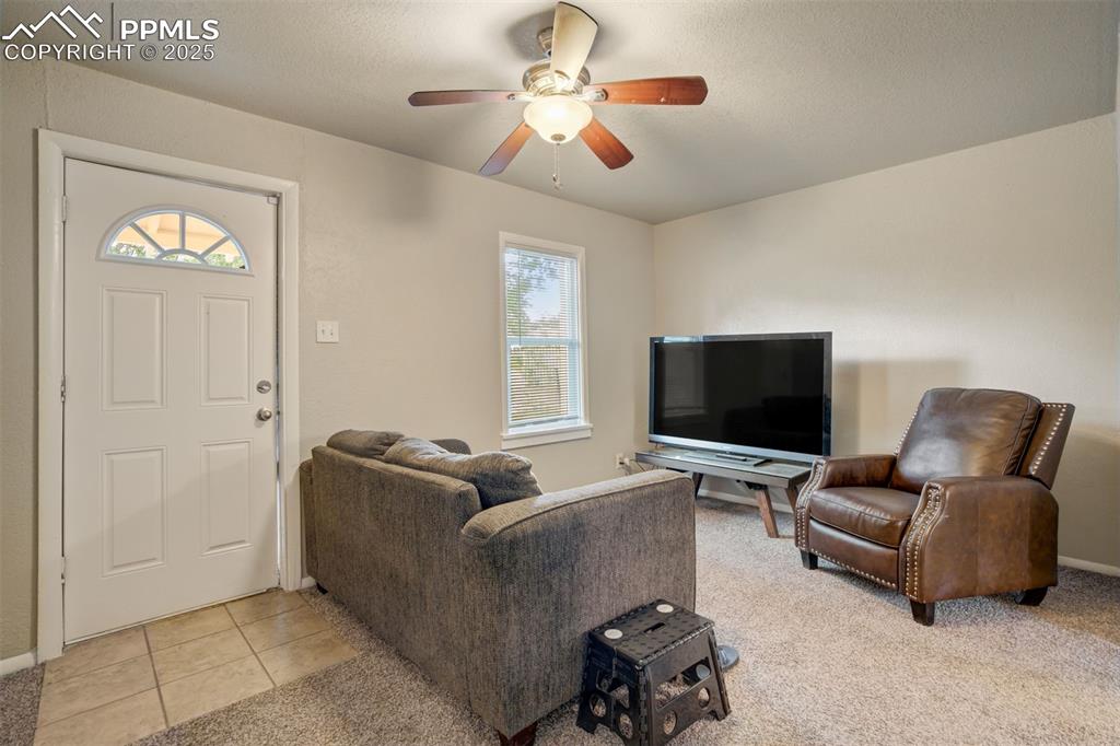 Image 4 of 24: Living room with plenty of natural light, ceiling fan, light carpet, and li