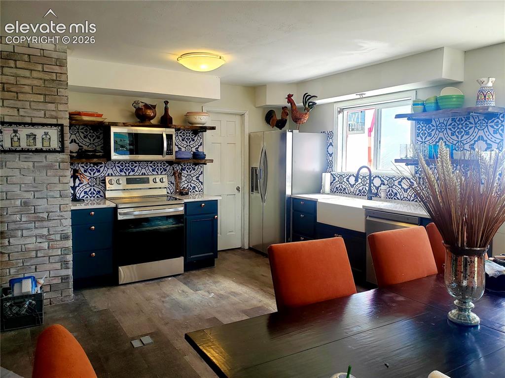 Image 8 of 12: Modern kitchen featuring patterned blue and white tile backsplash, stainles