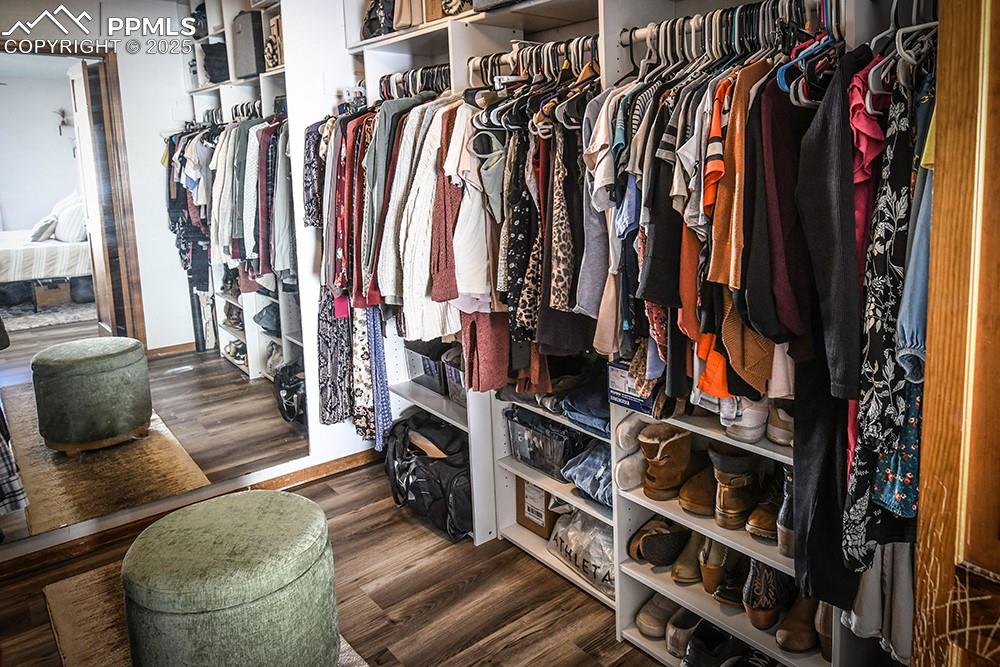 Image 16 of 20: Spacious closet with dark wood finished floors