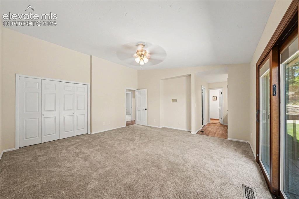 Image 14 of 42: primary bedroom walk out and adjoining bath 2 closets