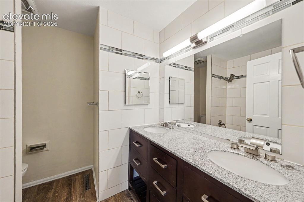 Image 20 of 42: hall bathroom Double vanity with a granite-style countertop and integrated