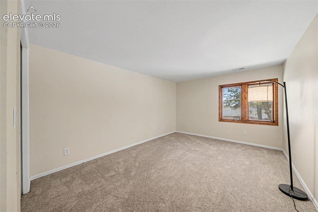 Image 25 of 42: Carpeted room with a double-pane window featuring wood framing