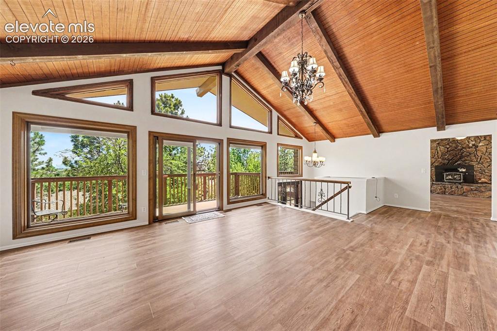 Image 4 of 42: Vaulted wood-paneled ceilings with exposed beams, wood-finish flooring, and