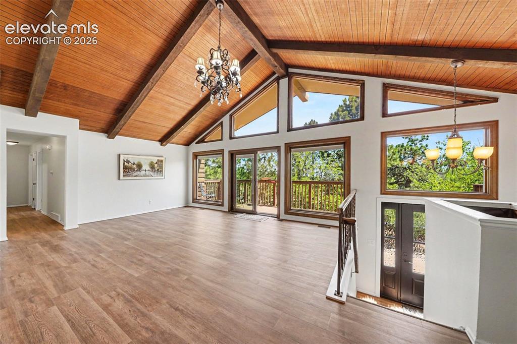 Image 6 of 42: Vaulted wood-paneled ceilings with exposed beams, wood-finish flooring, and