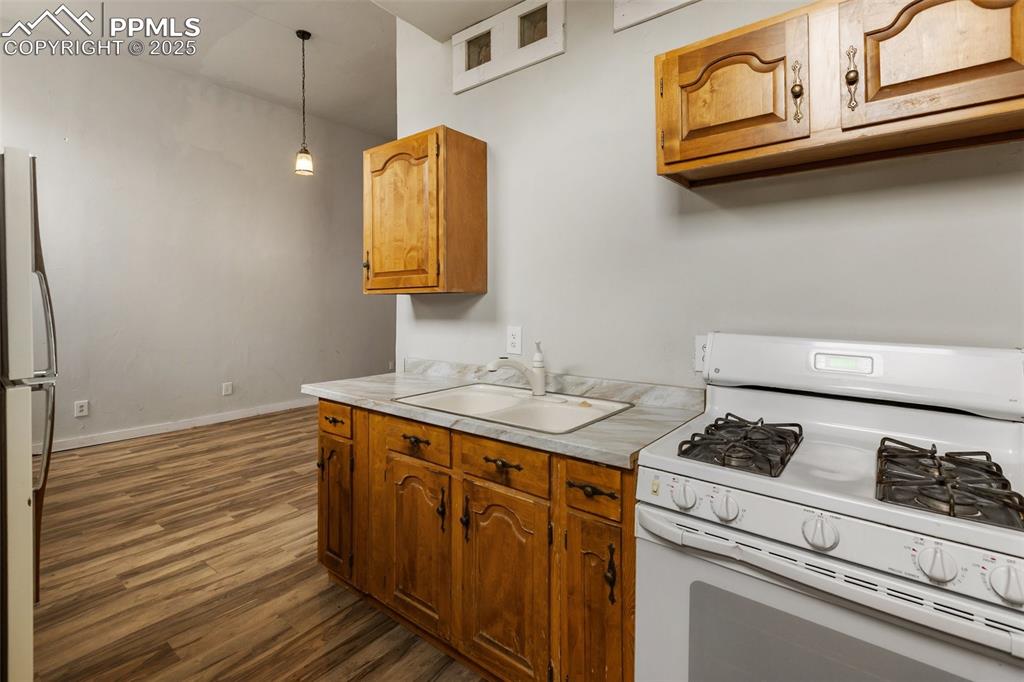 Image 20 of 34: Kitchen with white appliances, light countertops, dark wood-type flooring, 