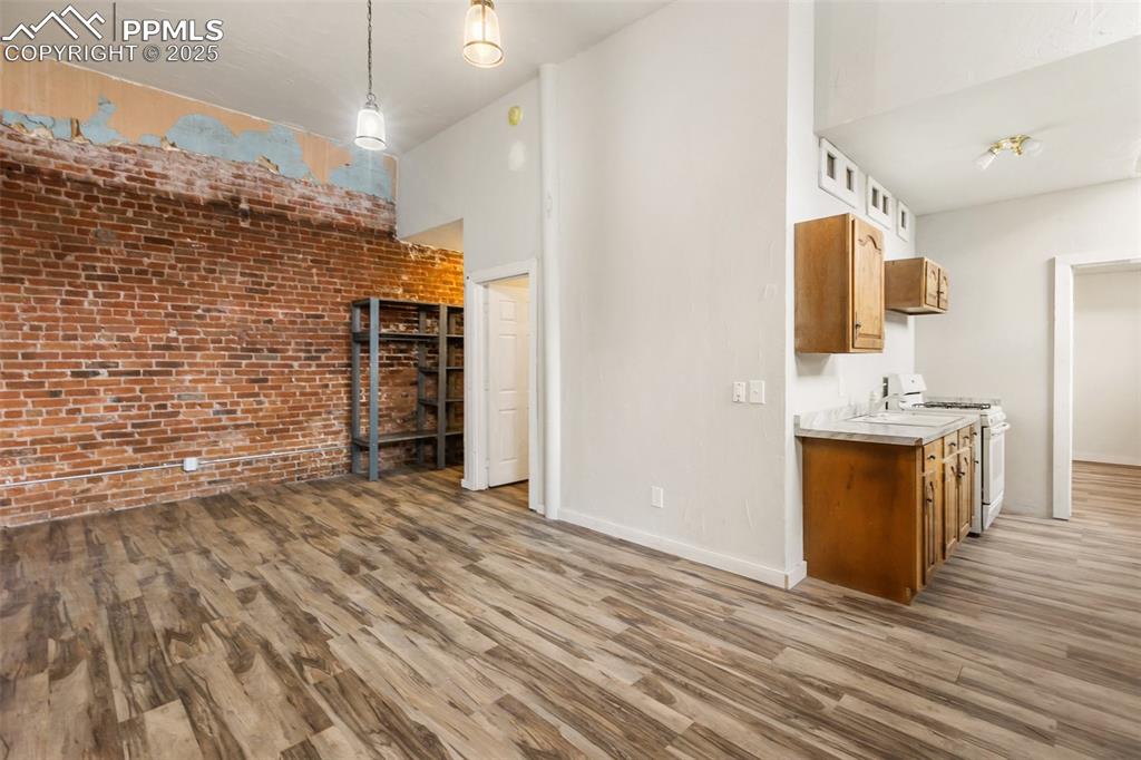 Image 22 of 34: Family room with exposed historic brick wall