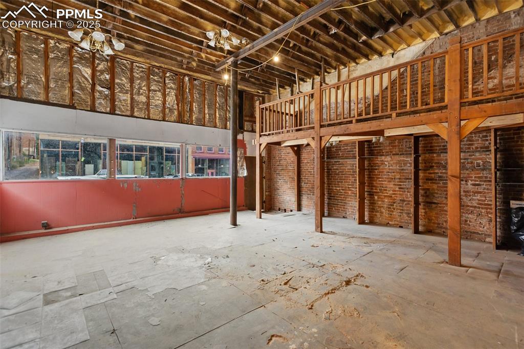 Image 4 of 34: Large open storefront interior with exposed brick walls and high ceilings —