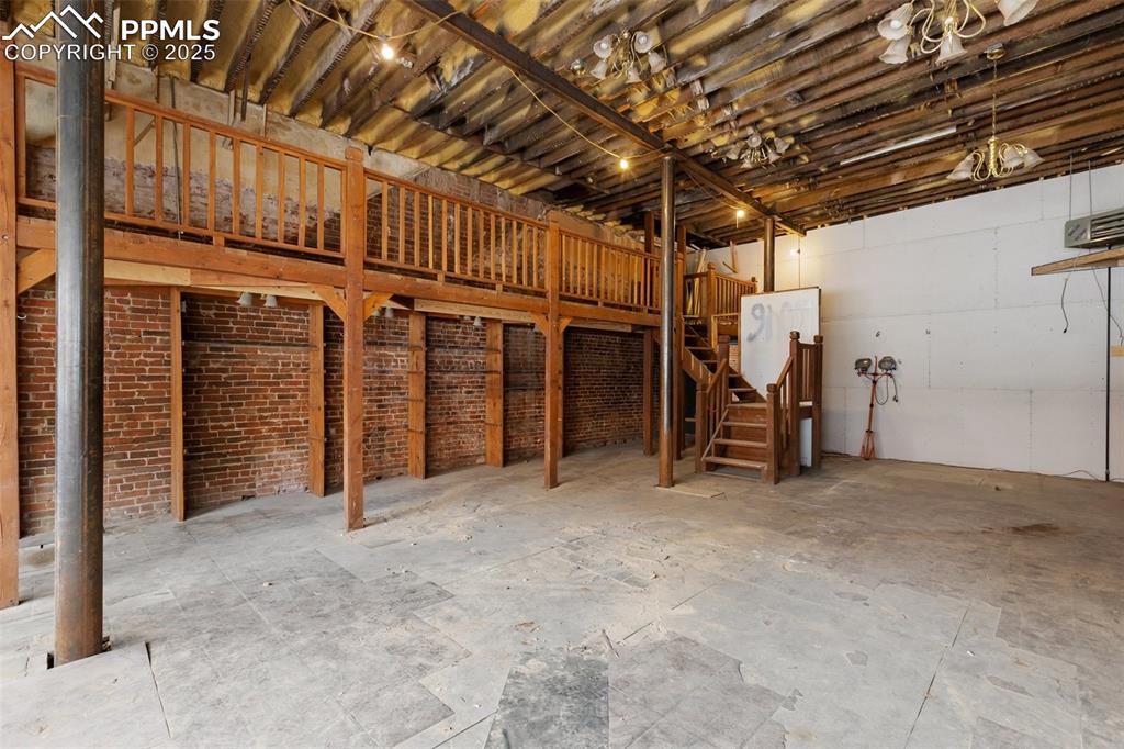 Image 9 of 34: Unfinished interior with structural steel reinforcement and open floor plan