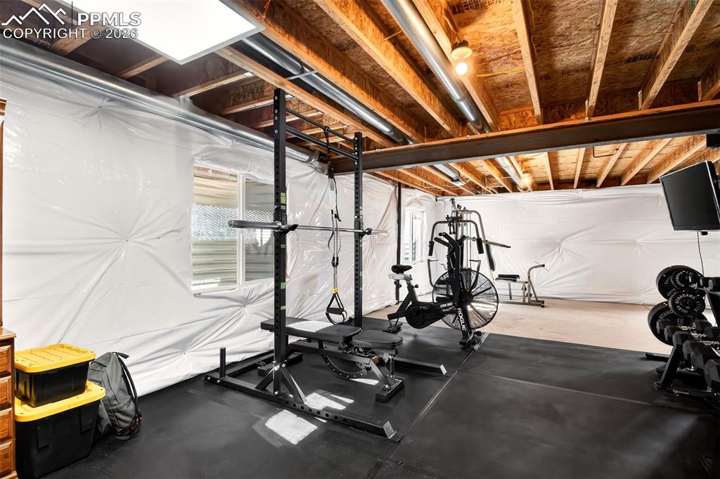 Image 24 of 36: Unfinished basement being used as workout area