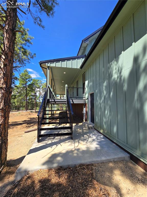 Image 10 of 50: View of garage side entry and stairs to wrap around covered porch