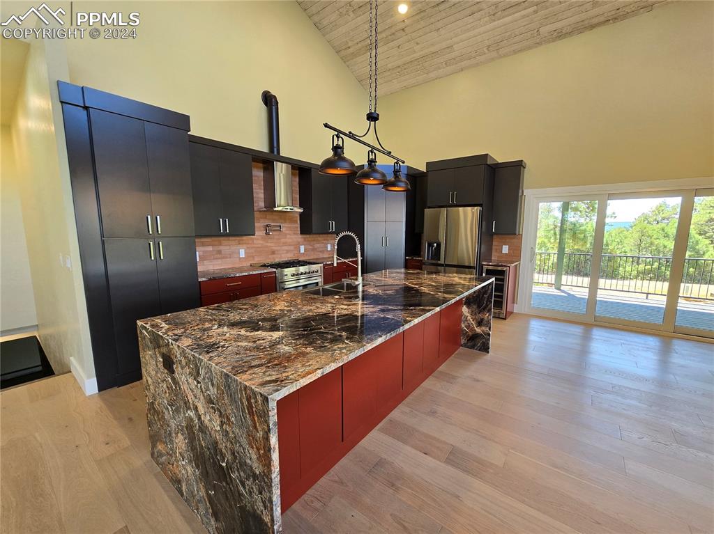 Image 17 of 50: Kitchen featuring hanging light fixtures, appliances with stainless steel f