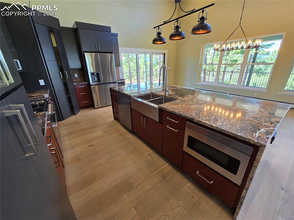 Image 24 of 50: Kitchen featuring pendant lighting, light hardwood / wood-style flooring, s