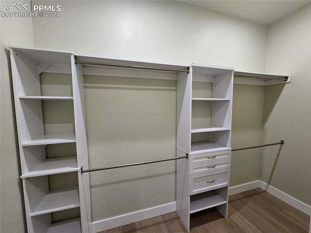 Image 34 of 50: Spacious closet with dark hardwood / wood-style floors