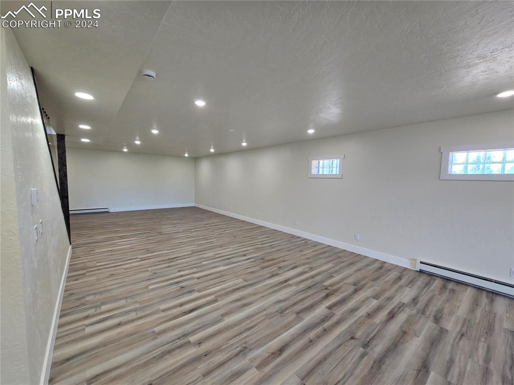 Image 39 of 50: Basement with a textured ceiling, light hardwood / wood-style flooring, and