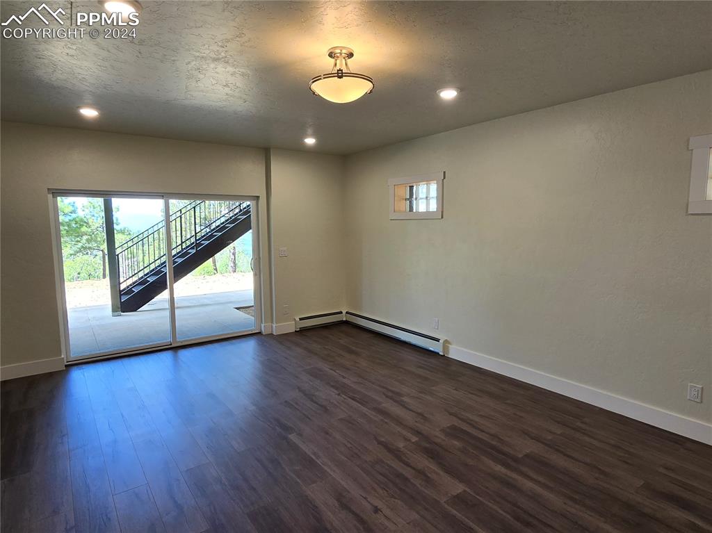 Image 43 of 50: Lower level bedroom featuring a baseboard heating unit, dark wood-type floo