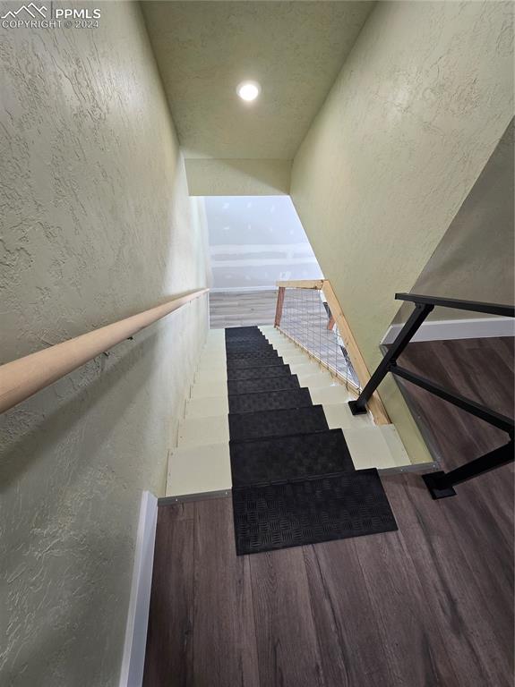 Image 45 of 50: Stairway featuring hardwood / wood-style flooring