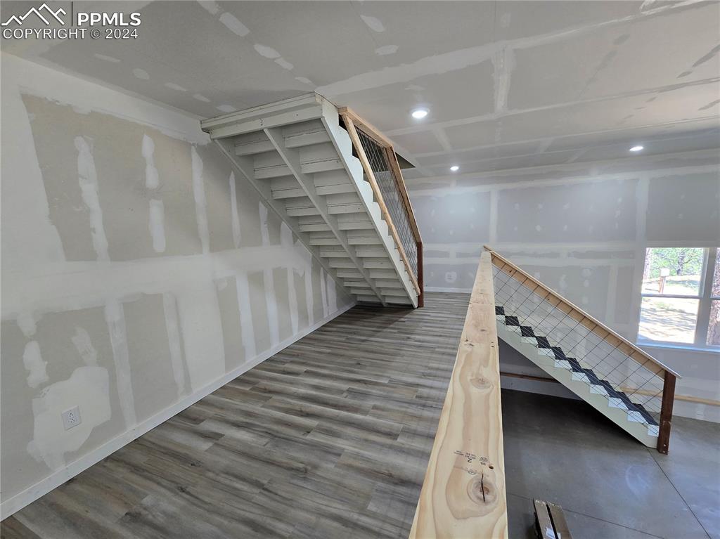 Image 49 of 50: Staircase with hardwood / wood-style floors
