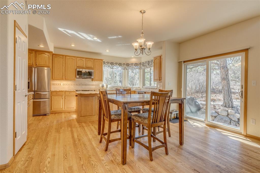 Image 15 of 48: Dining area with a chandelier and light wood-type flooring