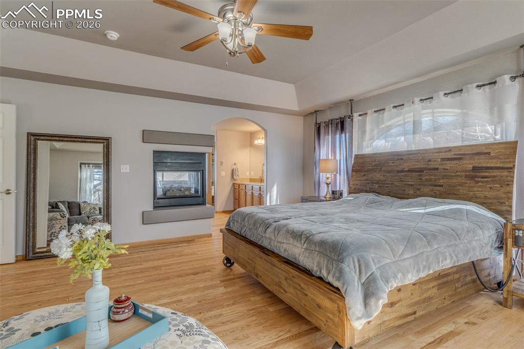 Image 26 of 48: Bedroom with light wood-type flooring, multiple windows, a ceiling fan, and