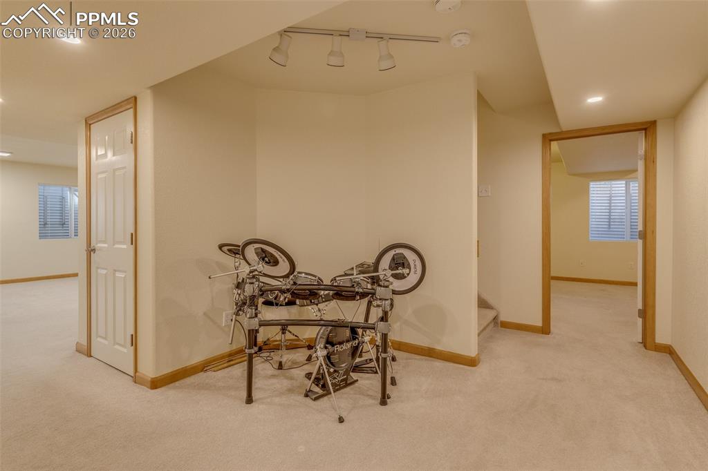 Image 38 of 48: Hallway featuring light carpet and rail lighting