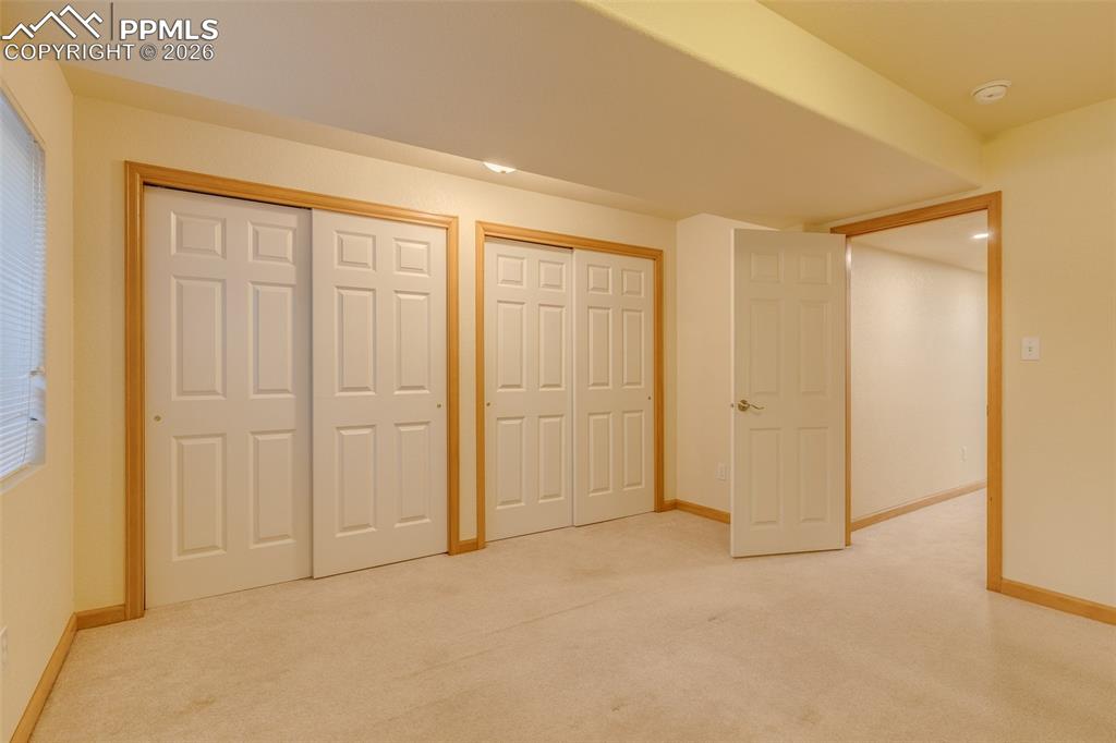 Image 40 of 48: Unfurnished bedroom featuring two closets and light colored carpet