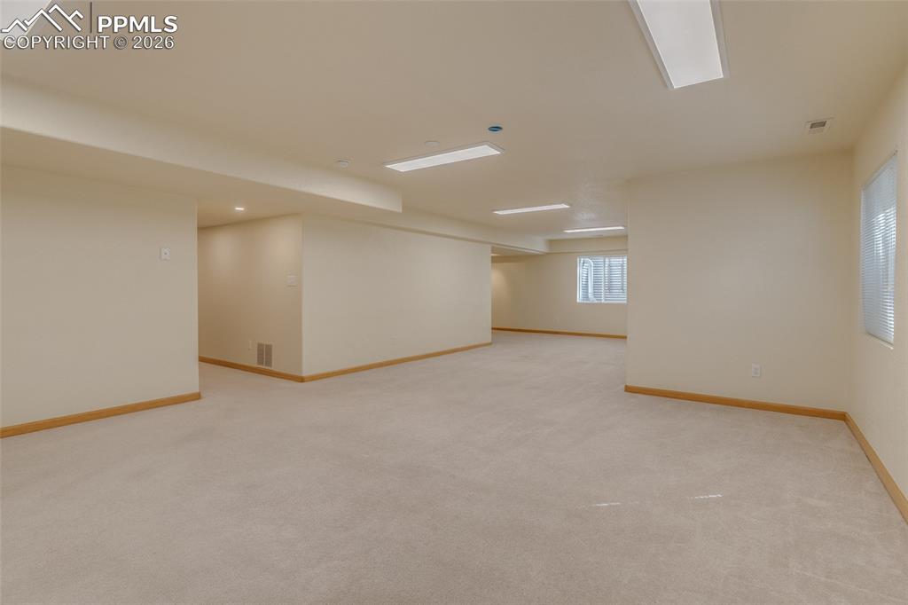 Image 45 of 48: Basement with light colored carpet and baseboards