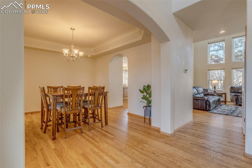 Image 9 of 48: Dining room featuring light wood-style floors, crown molding, suspended lig