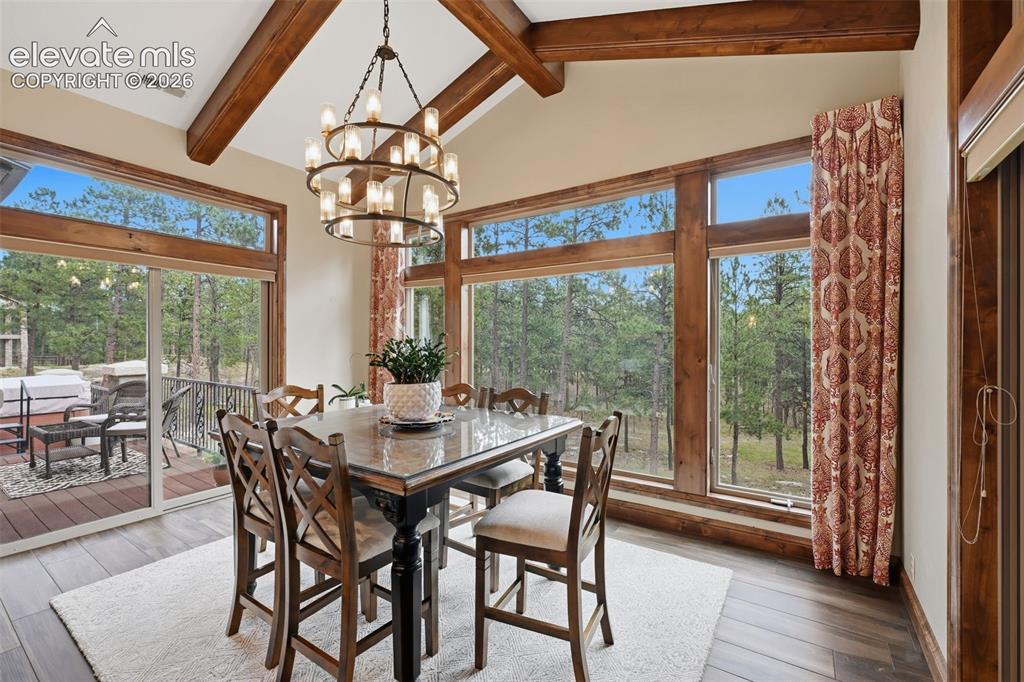 Image 13 of 50: Your dream eating area with beamed ceiling and walk out to both decks!