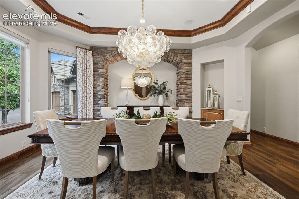 Image 15 of 50: Huge dining room with stone wall and coffered ceiling!