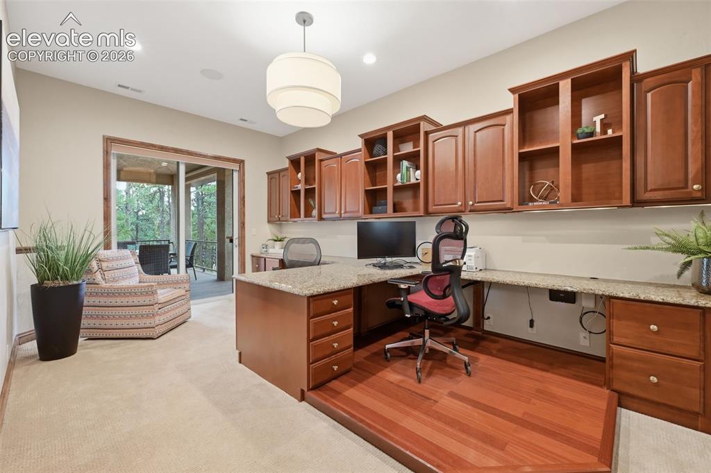 Image 17 of 50: Main level office with two builtin desks, walk out to deck and walk in clos