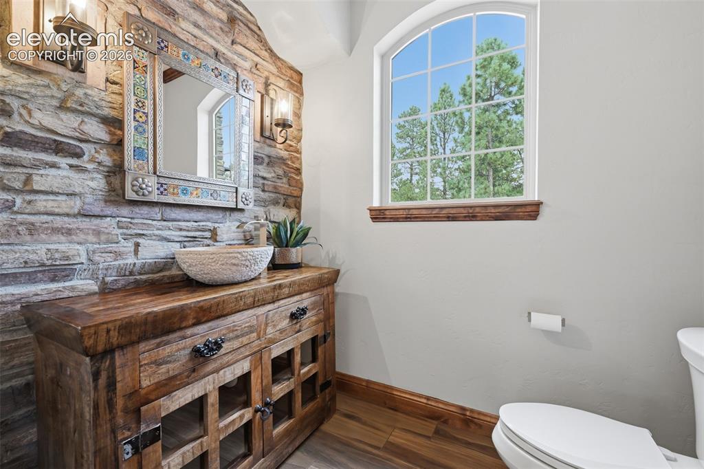 Image 18 of 50: Half bath with stone wall and custom sink!