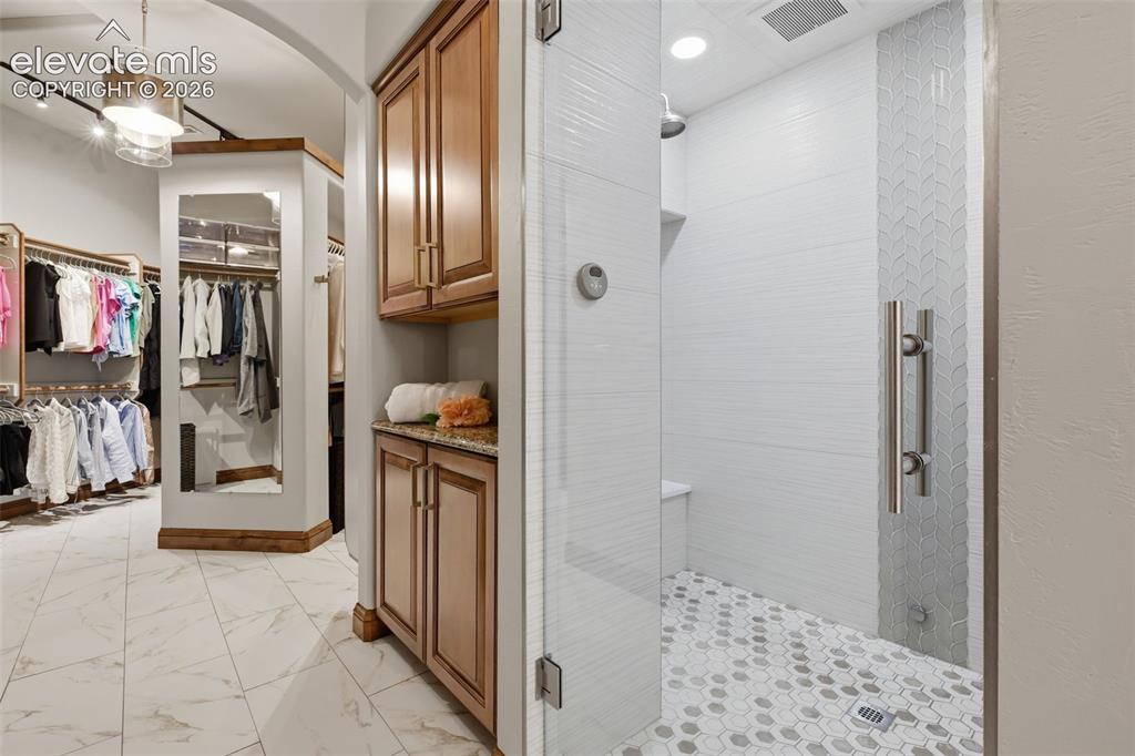 Image 24 of 50: Huge steam shower with his/hers shower spaces and built in cabinets!  Custo