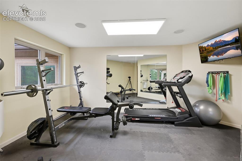 Image 43 of 50: Flex room above garage being used as work out room!  treadmill and bench in