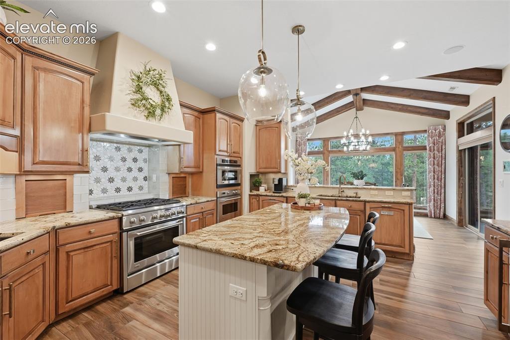 Image 9 of 50: Gorgeous kitchen with two sinks, two ovens, gas stove top and custom hood!