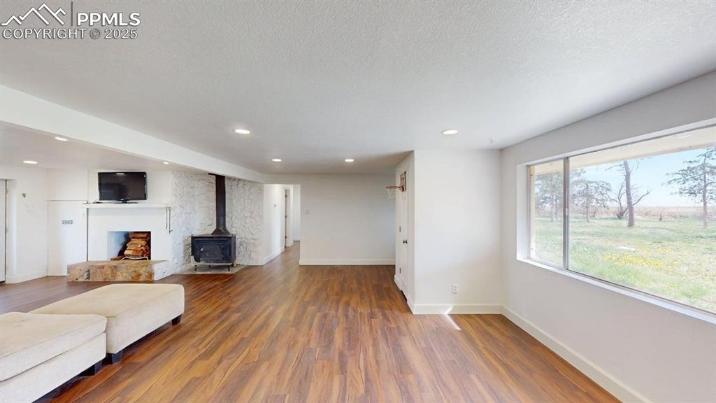 Image 11 of 27: Living room with wood finished floors, baseboards, recessed lighting, and a
