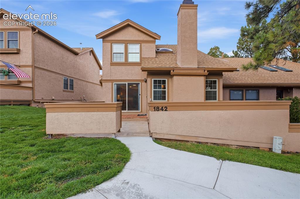 Image 1 of 35: Stucco exterior with a prominent chimney and multiple windows
