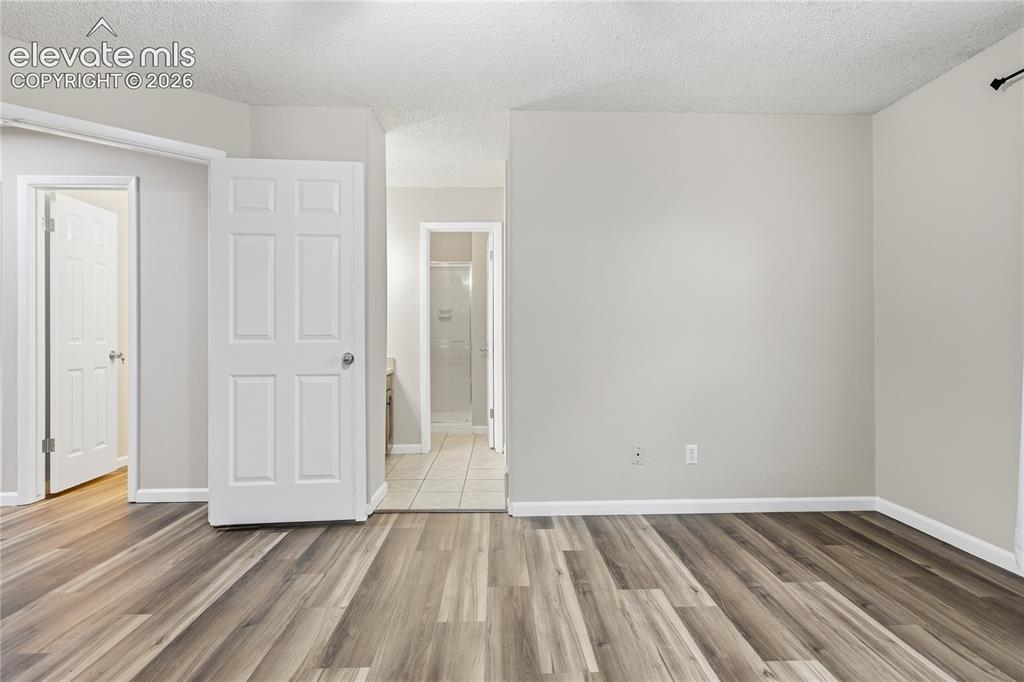 Image 20 of 35: Wood-finish flooring, light grey wall paint, white trim, and white paneled 