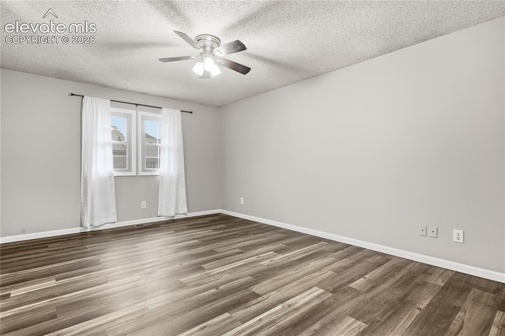 Image 21 of 35: Wood-finish flooring, light grey wall paint, two pane windows, and a ceilin
