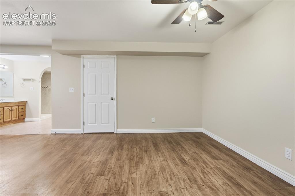 Image 30 of 35: Wood-finish flooring throughout, with neutral wall tones and a ceiling fan