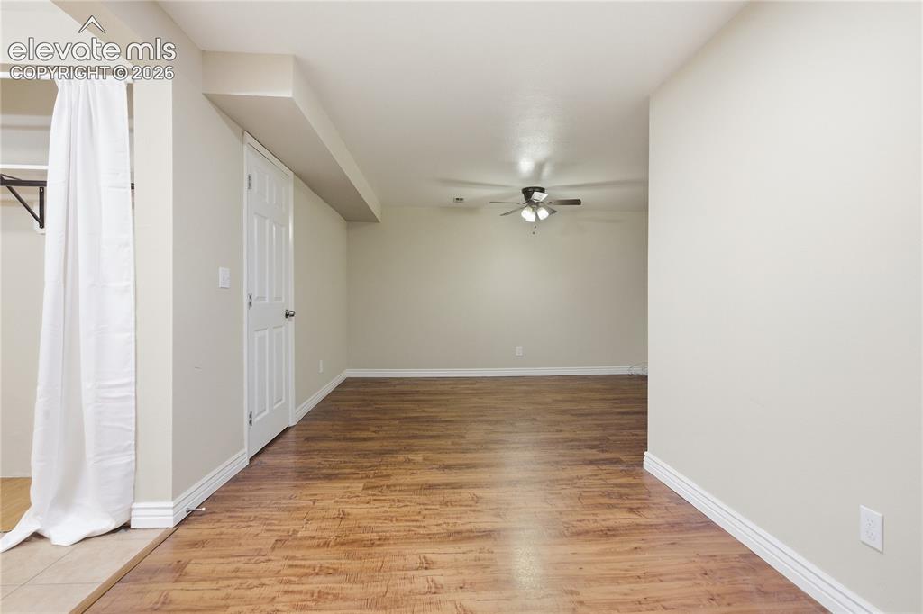 Image 31 of 35: Spacious room featuring wood-finish flooring, light-toned walls, and a ceil