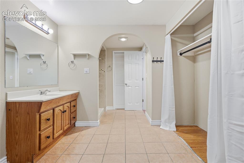 Image 32 of 35: Bathroom featuring a wood-finish vanity with a white countertop and integra